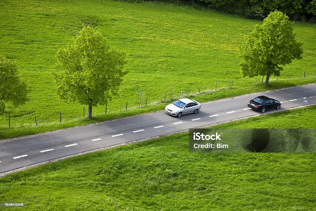 Dos coches rápidos en carretera de campo - Foto de stock de Coche libre de derechos