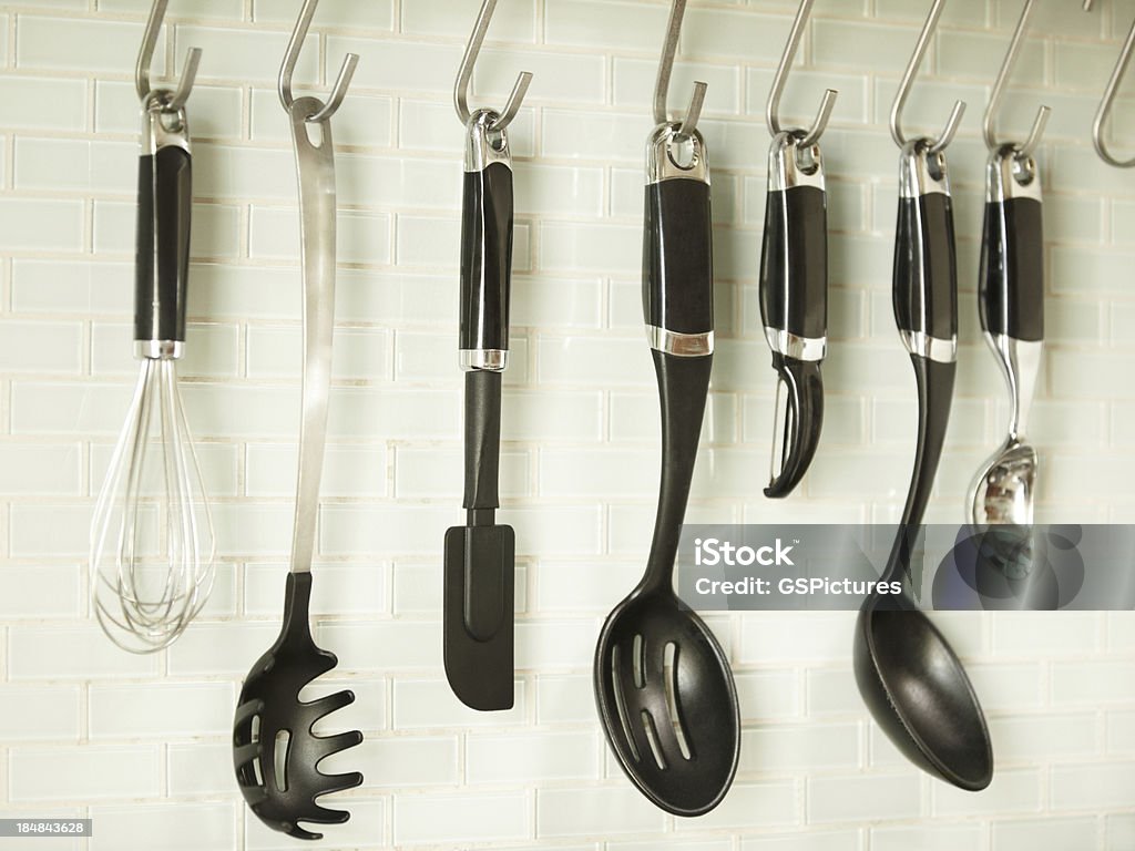 Utensili da cucina appeso su una parete di piastrelle bianco - Foto stock royalty-free di Plastica
