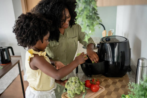 Mother teaching daughter how to prepare vegetables