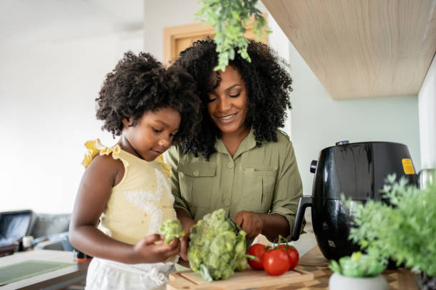 istock Mother teaching daughter how to prepare vegetables 1848437235