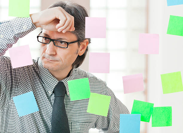 istock Pensive businessman with adhesive notes to the glass 184843817