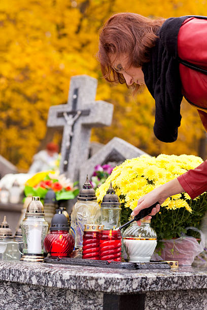 istock Woman lights a candle for cemeteries 184845077