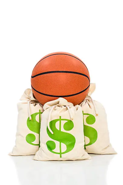 Concept-NBA Lockout. Basketball sitting on money bags against a white background