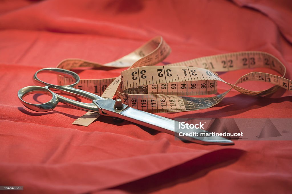 Schere und Maßband auf roten Stoff. - Lizenzfrei Alt Stock-Foto