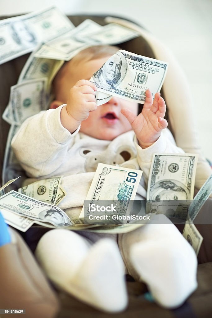 This paper is interesting! Portrait of an adorable baby boy playing with dollars at home Baby - Human Age Stock Photo