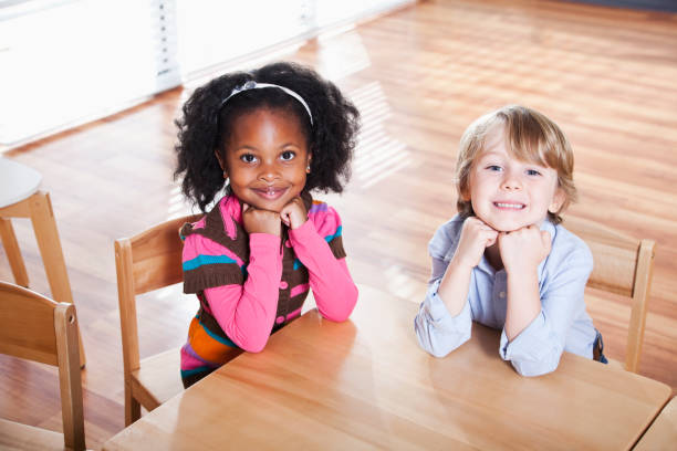 istock Preschoolers sitting at table in classroom 184845839