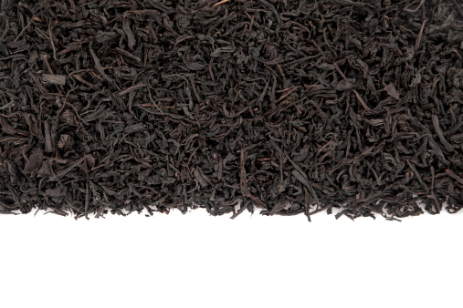 Black tea leaves on white background