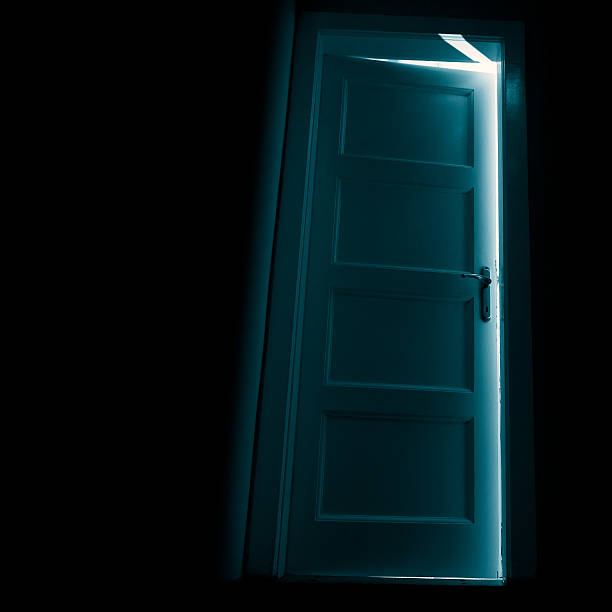 ダークドアの後ろに輝きを放つ - basement spooky cellar door ストックフォトと画像