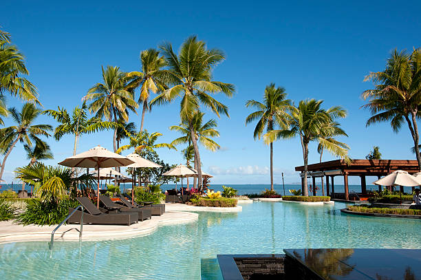 istock Swimming pool surrounded by palm trees at resort 184846493