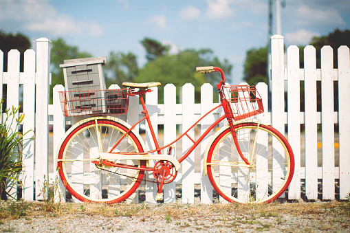an old antique bicycle rests along a white picket fence