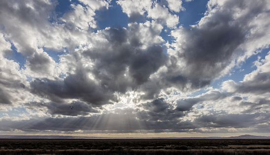 Crepuscular rays peaking through clouds along Highway 5 in Bakersfield, California.