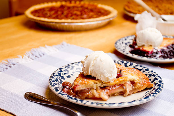Slice of Apple Pie with Ice Cream Slice of Apple Pie with Ice Cream fresh baked a la mode closeup on blue gingham apple pie a la mode stock pictures, royalty-free photos & images