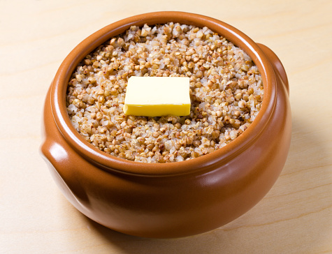boiled buckwheat with butter ceramic in pot - traditional russian kasha