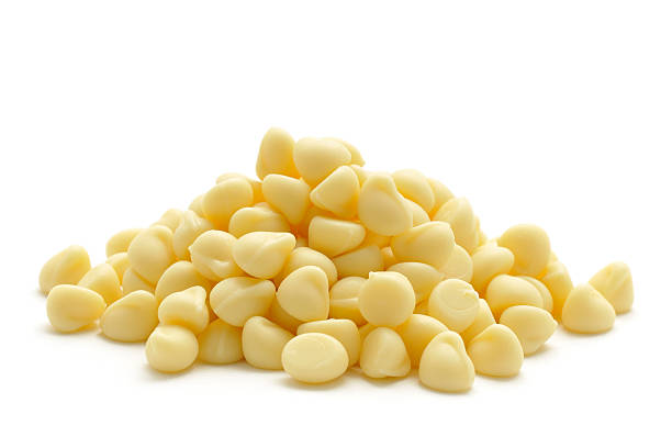 White Chocolate Drops A small pile of white chocolate drops isolated on white. chocolate white chocolate chocolate chip white stock pictures, royalty-free photos & images