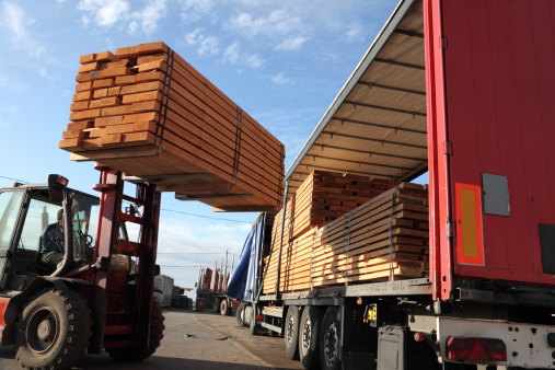 Forklift loading stacks of beech boards on a truck. Please see similar pictures :