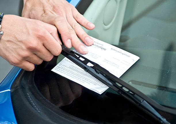 parking  prohibition - violation ticket human hand gets an parking  prohibition ticket behind wiper no parking sign photos stock pictures, royalty-free photos & images