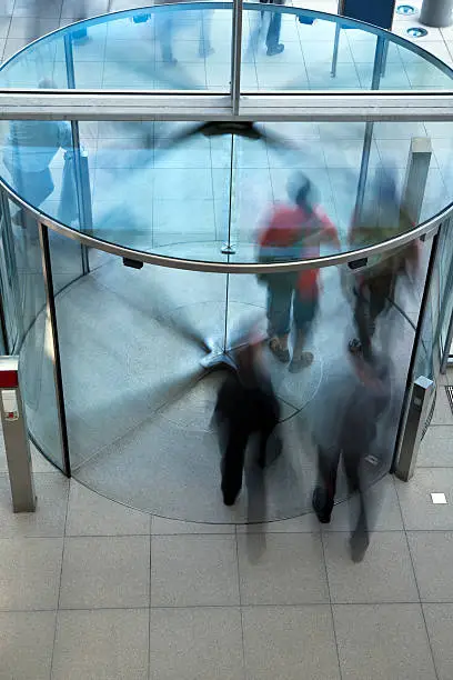 Photo of People Exiting Building Through Revolving Door