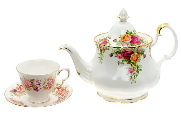 Vintage bone China teapot and a cup and saucer - studio shot with a white background