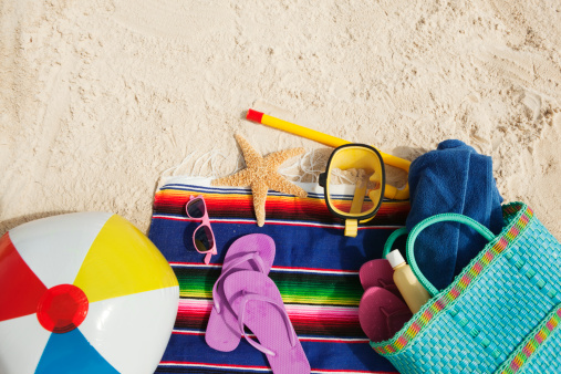 Subject: Various beach gear resting on the sandy beach with copy space.
