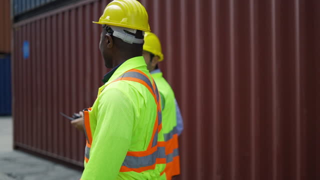 Businessman consulting about plan and inspecting with logistic staff in warehouse container port area.