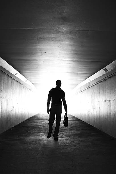 istock Lone businessman walking through tunnel with briefcase 184850043