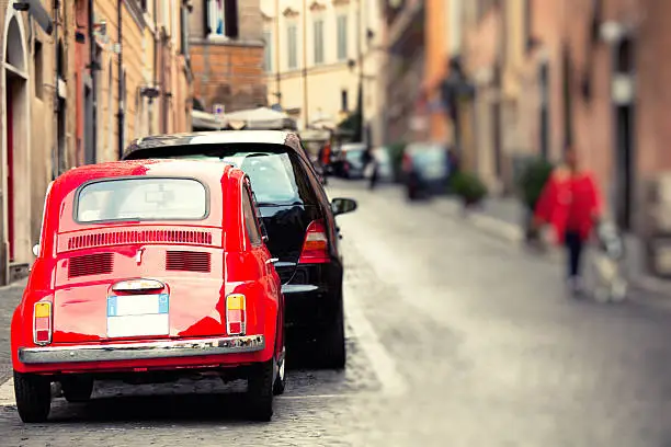 A red the Fiat 500 along the streets of Rome. Tilt and shift effect