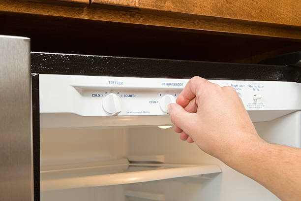 main ajuster le nouveau réfrigérateur bouton thermostat - température photos et images de collection