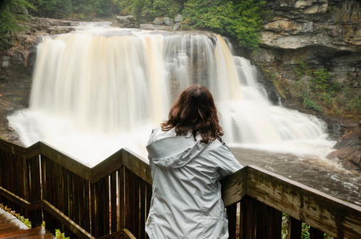 Woman admiring the Blackwater Falls located in the state park by the same name in West Virginia.