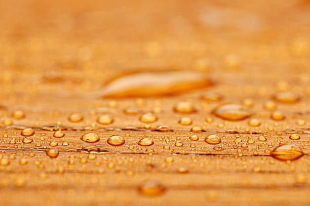 Protected wood after rain - covered with water drops "Protected wood with water droplets. Natural oak parquet . Wood floor painted , protected with natural oil. Close - up, macro. Very shallow DOF. The grain and texture added." wet wood texture stock pictures, royalty-free photos & images