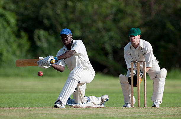 Cricket "Cricket action, batsman playing a sweep shot watched by the wicketkeeper." cricket player photos stock pictures, royalty-free photos & images