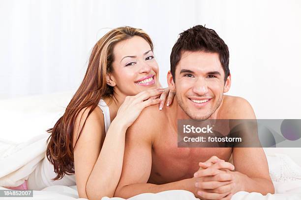 Foto de Feliz Casal Jovem Deitado Na Cama De Plumas e mais fotos de stock de 20-24 Anos - 20-24 Anos, 30 Anos, Adulto