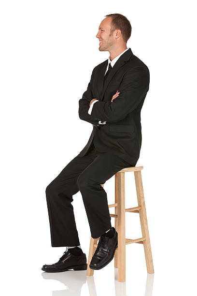 istock Businessman sitting on stool with arms crossed 184852915