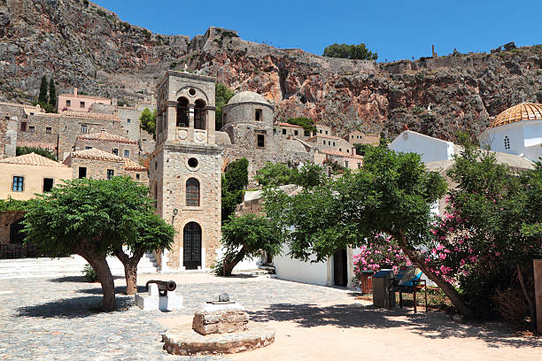 Central Square and Cathedral, Monemvasia, Laconia Region, Peloponnese, Greece "The small cobbled central square, 13th century cathedral and campanile (bell tower) of Monemvasia.  The ramparts of the medieval castle occupy the massive summit of this charming Byzantine town which is located in the Laconia region of the Peloponnese.  The town is attached to the mainland by a single thin causeway." monemvasia stock pictures, royalty-free photos & images