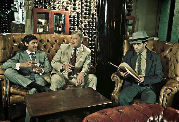 Retro Business "3 retro businessmen at lunch, sip wine while waiting to be seated. Retro coloring, intentional grain." organized crime photos stock pictures, royalty-free photos & images