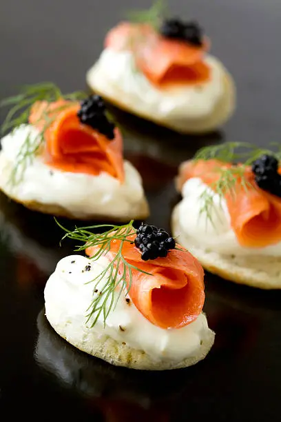 Smoked salmon blinis with caviar and a sprig of fresh dill.