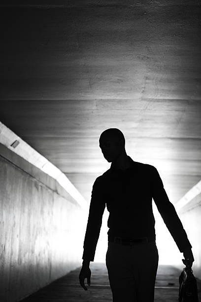 istock Lone businessman walking through tunnel with briefcase 184853870