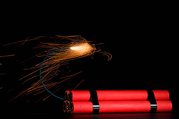 Dynamite Sticks of Dynamite with lit fuse, sparks a flying, agaisnt a black background hand grenade photos stock pictures, royalty-free photos & images