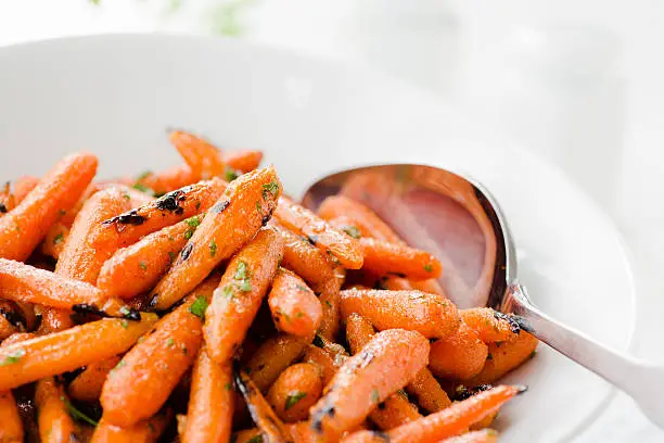 Close up of a serving bowl of grilled honey glazed baby carrots.Similar Images:
