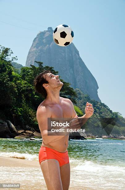 Homem A Jogar Futebol Na Praia - Fotografias de stock e mais imagens de Homens - Homens, Calções de Natação, Praia