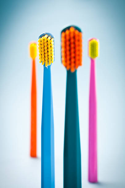 gruppe von bunten zahnbürsten stehen - toothbrush pink turquoise blue stock-fotos und bilder