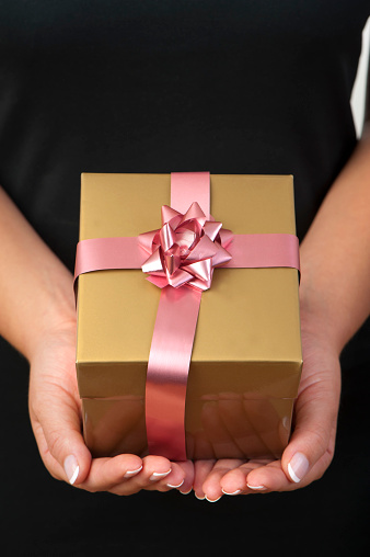 Close up of a womans hands Giving a gift