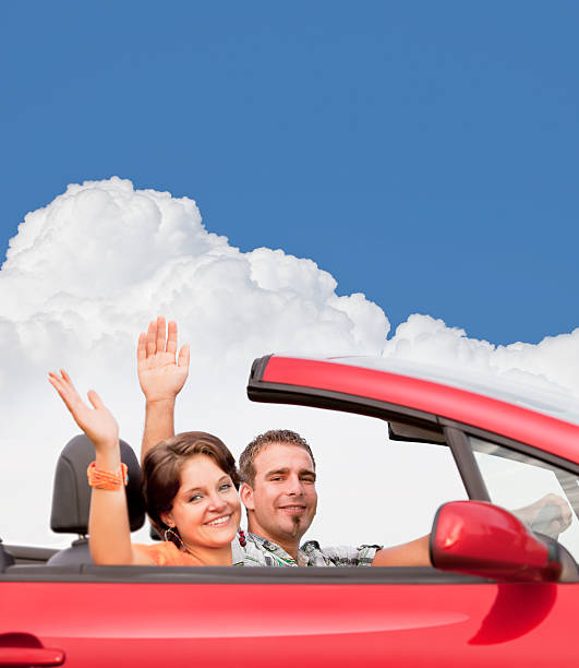 istock Couple with hands up having fun in red cabriolet 184856385
