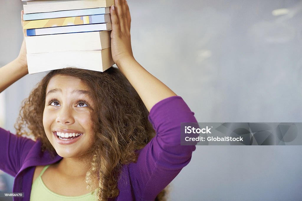Heureuse jeune fille avec des livres sur la tête - Photo de Livre libre de droits