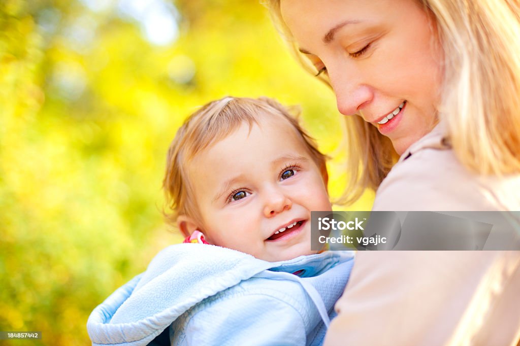Mère tenant main et jolie souriant bébé fille en plein air - Photo de 12-17 mois libre de droits
