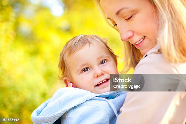 Photo libre de droit de Mère Tenant Main Et Jolie Souriant Bébé Fille En Plein Air banque d'images et plus d'images libres de droit de 12-17 mois