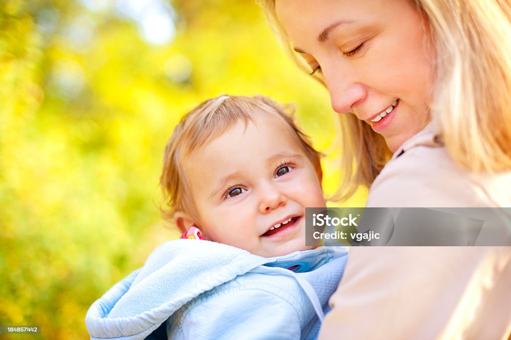 Mãe segurando e carregar linda sorrindo Bebê Menina ao ar livre - Foto de stock de 12-17 meses royalty-free