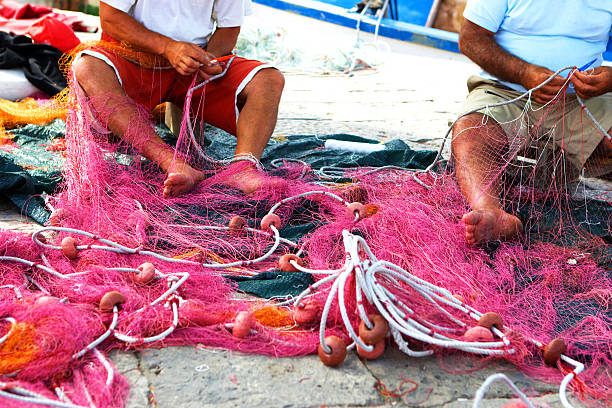 istock Fisherman repairing the nets 184858178