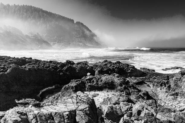 Retro, monochrome image of fog and mist on the seascape of central Oregon on the Pacific Ocean coastal mountain landscape.