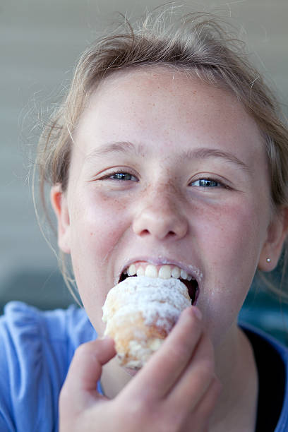 istock Blonde girl eating a sugary donut. 184858238
