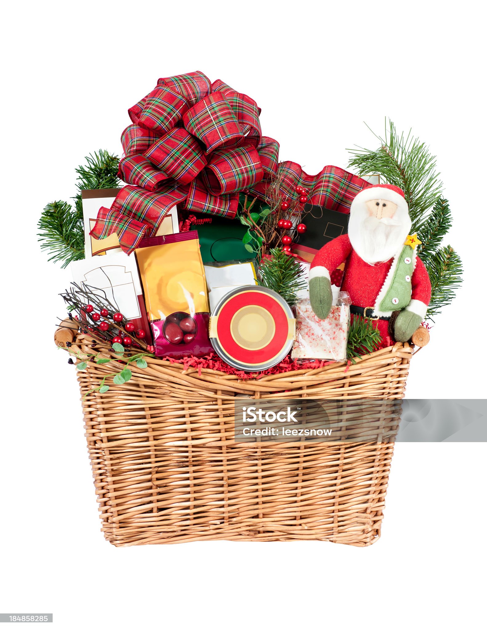 Christmas Gift Basket on White A festive holiday gift basket filled with a variety of goodies including Santa Claus. Isolated on white. Basket Stock Photo